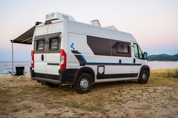 Campervan or motorhome parked on the beach in Greece. Rv campervan is wild camping on the beach in...