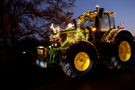 John Deere R6 bei der Lichterfahrt in Rinteln mit Weihnachtsbeleuchtung bei der Vorbeifahrt mit Rentierschlitten, ein Funken Hoffnung in der Abendd&auml;mmerung