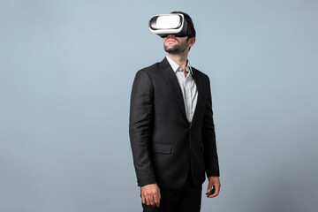 Skilled project manager with VR glasses standing and looking around. Caucasian businessman...
