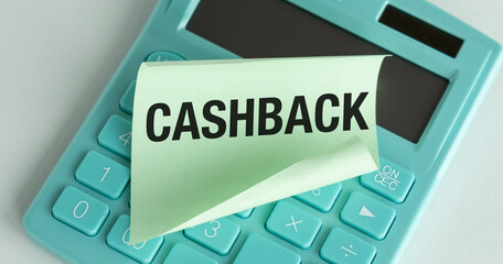 Cashback text on a sticker lying on a calculator against the background of an office table,...