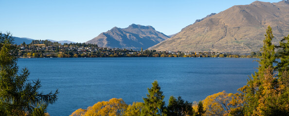 Panoramic scenery of beautiful landscape at the waterfront of Lake Wakatipu, with Kelvin Peninsula and majestic mountains in the distance. Panorama scenic view of Queenstown, New Zealand.