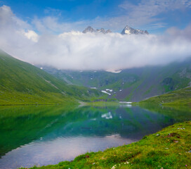 small calm lake among green mountain