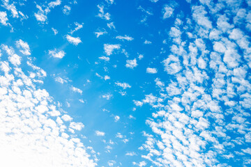 White clouds in small droplets across the blue sky. Sky background