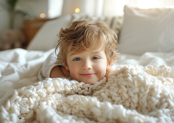 Cute Little boy in a white cloth lying in a bed in a bright bedroom.