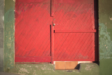 Puerta de tablones de madera pintada de rojo en calle