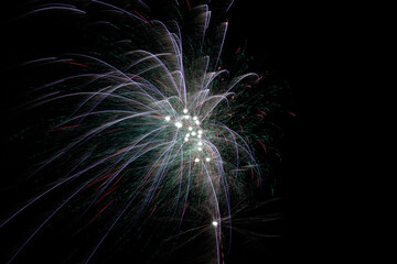 primo piano su dei fuochi d'artificio con varie sfumature di colore, su sfondo nero