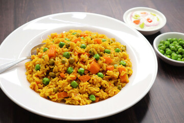 Carrots and Peas Pilaf or Gajar Matar Pulao. It is a one pot rice dish made with Basmati Rice and Vegetables, seasoned with spices, Served with yogurt raita or curd. Healthy weight loss meal. copy
