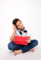 Portrait of caucasian boy sitting on floor using tablet in casual outfit isolated over white background