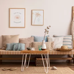 Fotobehang Sunny and bright space of living room with stylish sofa, pillows, coffee table, mock up poster frames, decorations, furnitures and personal accessories. Cozy home decor. Template. Summer vibe. © FollowTheFlow