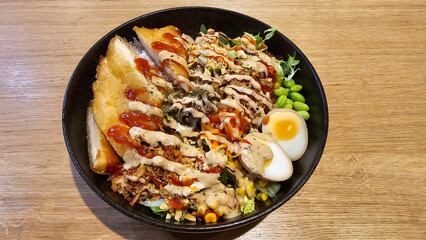 A bowl plate of staple food with eggs and bread on a wooden table Hanover