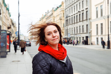 Fototapeta premium melancholy sad pensive young caucasian female woman with flowing hair looking at camera on street of european city. mental health concept. lifestyle portrait