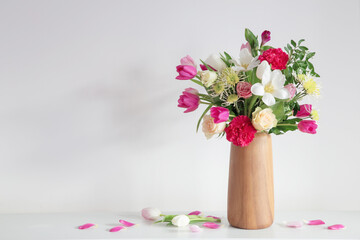 beautiful flowers  in vase on shelf  on background white wall - 795063854