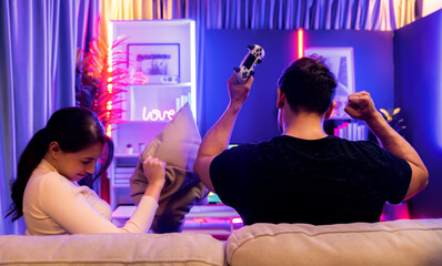 Man winner fighting gamer on video game beside woman loser challenge at back side view. Couple...