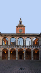 Fototapeta na wymiar Dusk descends on the inner courtyard of the University of Bologna, with the clock tower standing as a historic beacon against the twilight sky