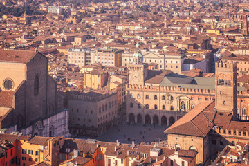 An aerial view of Bologna city center, showcasing the famous Piazza Maggiore. The scene is filled...
