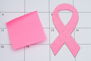 Mammogram appointment with pink ribbon and sticky note on a calendar