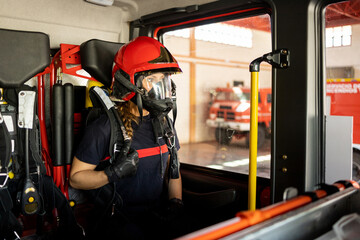 A woman in her 40s and 50s works as a firefighter dressed in her work uniform.The adult woman is...