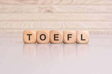 wooden cubes with letters form the expression TOEFL. education concept