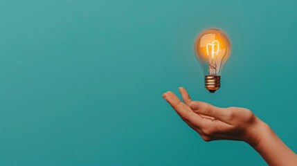 A person holding an incandescent light bulb in their hand against a plain background