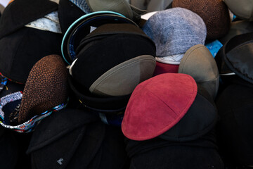 Colored and patterned yarmulkes or skull caps for sale in a Jewish religious neighborhood of...