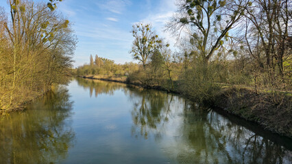 Water flowing through trees under sunny sky in natural landscape Leine Maschsee Hanover