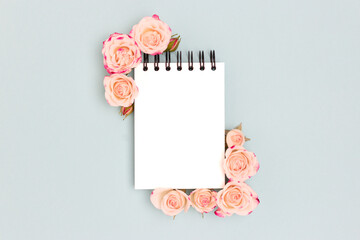 Empty notepad mock up. Pink rose flowers on a blue background. Floral concept.