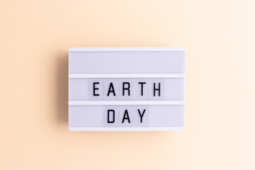 Earth day. White lightbox with letters on a beige background.