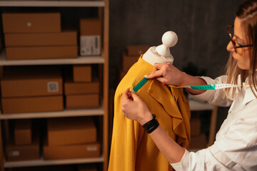 Tailor measuring mustard garment on mannequin