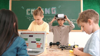 Energetic child wearing Vr headset while enter virtual world at classroom. Student programing...
