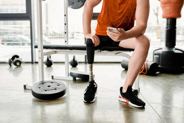 Fototapeta na wymiar Determined athlete with a prosthetic leg resting during an inspiring gym workout session.