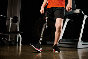 A disabled man, with a prosthetic leg, standing in the gym as he works out.