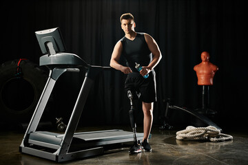A disabled man with a prosthetic leg stands on a treadmill in a dark room, focused on his workout...