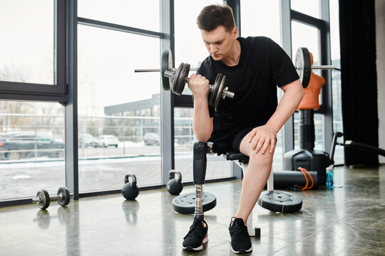 A determined man with a prosthetic leg performs a squat while holding a dumbbell in a gym. - Powered by Adobe