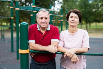 Elderly man and woman posing in open-air sports bars complex - 795124067