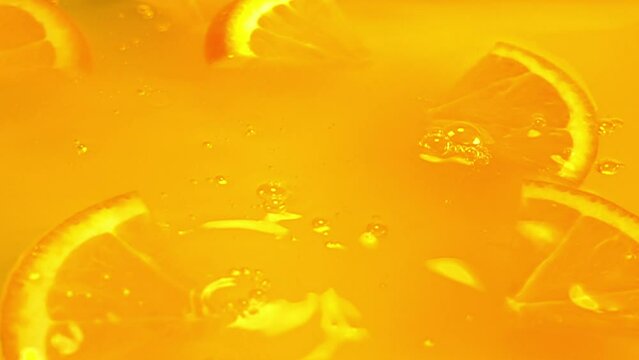 close up of natural orange slices in juice, advertising of tropical fruit juice, background, slow motion