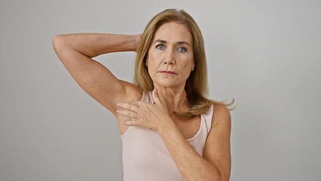 Mature blonde woman checking axilla isolated on a white background