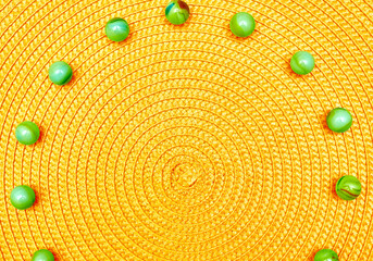 Yellow spiral round straw background with green balls. Place for text