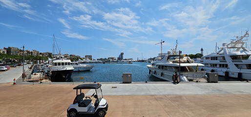 View of a harbour in Barcelona, Spain, with luxury yachts and motorboats, blue sea and blue sky...