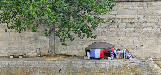 A homeless person’s tent on the banks of the River Siene in Paris, France; inequality in the...