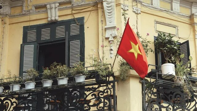 Hanoi, Vietnam - August 23, 2023: Vietnamese flag in a balcony at the Old Quarter