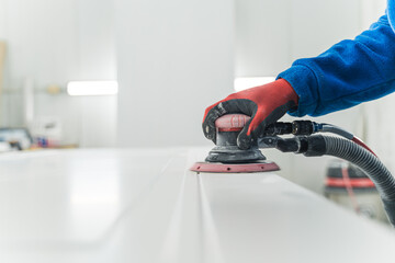 Carpenters use a sander to sand the surface of the wood to smooth the woodwork before painting....