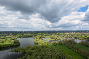 Fototapeta na wymiar Cloudy day, trees encircling lake, natural landscape view from above Hanover Germany
