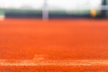 base line of clay tennis court before line brushing process with blurred court as background