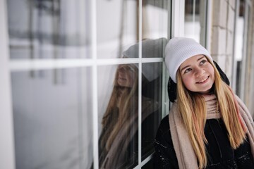 Portrait of a teenage girl at the windows of her home.