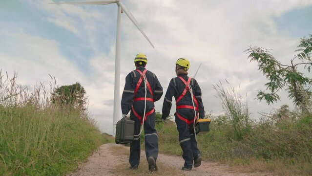 wind turbine maintenance asian technician in a safety suit inspects a wind farm.Maintenance, Sustainable Lifestyle, Renewable Energy concept