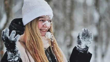 Teenage girl playing with snow.