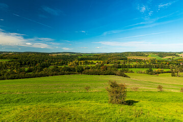 Fototapeta na wymiar Early autumn rolling landscape with meadows and forests near Plauen city in Germany