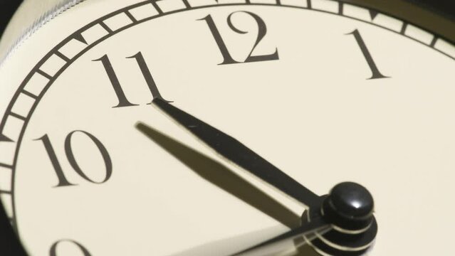 Clock Face Time Lapse. The hands of the clock rotate rapidly against the background of a light dial