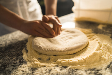 Cooking Italian pizza in a restaurant. Stretching raw pizza dough with your hands. A professional...
