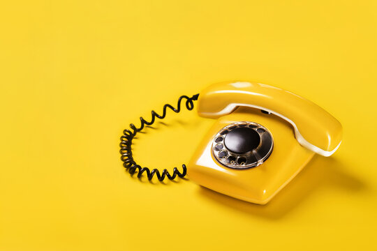 Yellow old stylish Phone, telephone with dial on yellow background copy space for your text banner